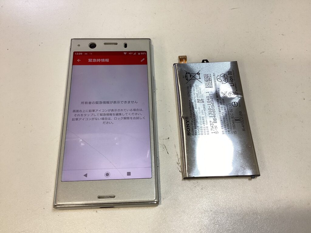 電源が入ったスマホと元々のバッテリー